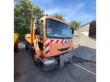 an orange truck parked in a parking lot next to a pile of dirt