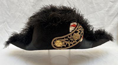 un chapeau noir orné d'une bordure dorée et un chapeau noir orné d'une bordure dorée