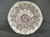 a clear glass object on a table with a black background