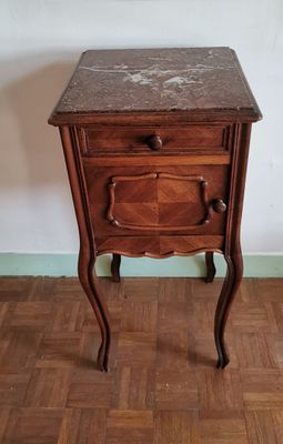 une petite table en bois avec un plateau en marbre, posée sur un parquet en bois dur