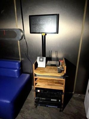 une télévision posée sur un meuble à côté d'un fauteuil bleu dans une pièce