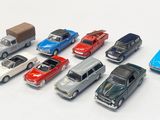 several toy cars are lined up in a row on a white surface