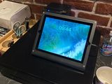 une tablette posée sur un socle noir
