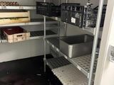 a metal shelf with baskets on it in a kitchen