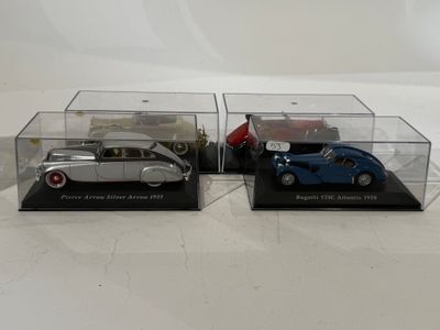 two model cars are sitting in clear boxes on a white surface