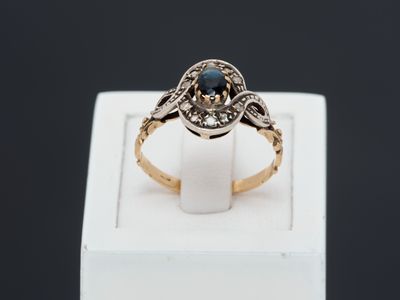 Gros plan sur une bague en or ornée d'une pierre bleue