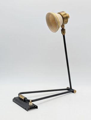 une lampe noire et dorée avec un pied en bois, sur fond blanc