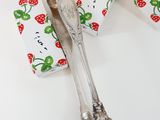 a silver spoon and a box of strawberries on a table