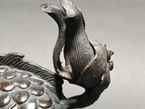 a close up of a vase with a bird on it