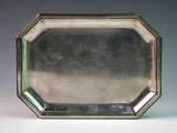 an antique silver plate with a green glass in the center