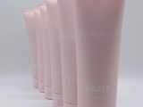 six pink plastic tubes are lined up on a white surface