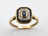 un gros plan d'une bague en or ornée d'un saphir et d'un diamant au centre