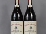 two bottles of red wine sitting on top of a table