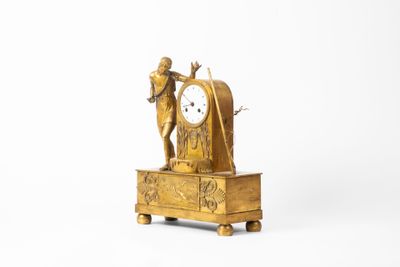 une horloge en or surmontée d'une statue