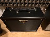 a black amp sitting on a wooden floor next to a speaker