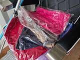 a black chair with a blue handle and a bag of clothes in it