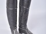 pair of black leather boots on a white surface with a white background