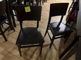 de nombreuses chaises noires dans un magasin, avec une étiquette de prix fixée à l'arrière