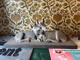 a statue of a dog and a cat laying on a pillow
