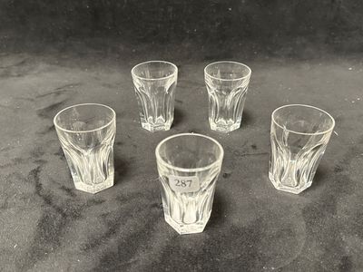quatre verres à shot posés les uns à côté des autres sur une table