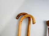 two wooden walking canes on a wall next to each other