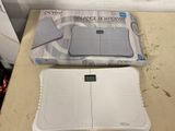 a white electronic scale sitting on a counter next to a box
