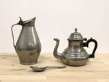 une théière en argent et une théière en argent posées sur une table en bois