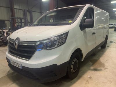 La camionnette blanche est garée dans un entrepôt, à côté d'autres véhicules.
