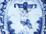 a blue and white plate with a picture of jesus on the cross