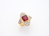 une bague en or sertie d'une pierre rouge et de diamants blancs