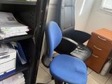 une chaise de bureau bleue placée devant une bibliothèque