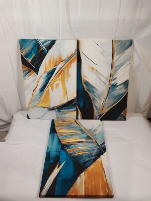 deux tableaux posés sur un lit aux draps blancs et un drap blanc