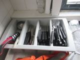knives and utensils are in a drawer in a kitchen
