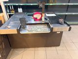 un comptoir en métal sur lequel est accrochée une pancarte, dans un magasin