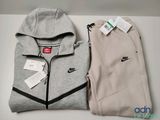 two pairs of nike sweatpantss and a hoodie on a table