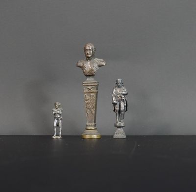 trois figurines en argent représentant des hommes et un buste d'homme sur un socle