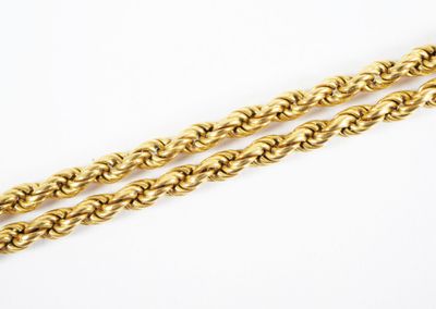 une paire de chaînes en or tressées sur fond blanc