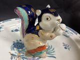 a small figurine of a cat sitting on top of a plate