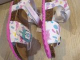 a pair of sandals on the floor next to a shoe box