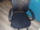 a black office chair sitting in front of a blue door