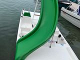 a green slide on the back of a boat in the water