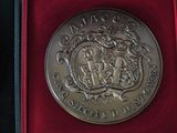 a silver coin in a red box on a black surface
