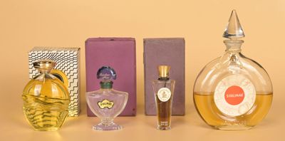 plusieurs flacons de parfum posés les uns à côté des autres sur une table