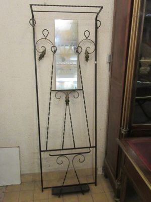 a mirror on a stand in the corner of a room