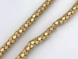 a close up of a gold chain on a white surface