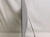 a computer monitor sitting on a stand on a white surface
