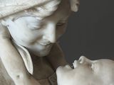 une statue de femme tenant un bébé dans ses bras