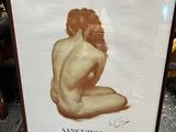 a framed picture of a naked man sitting on the ground