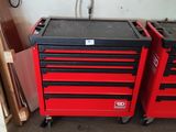 Deux caisses à outils rouges sont posées l'une à côté de l'autre dans un garage.