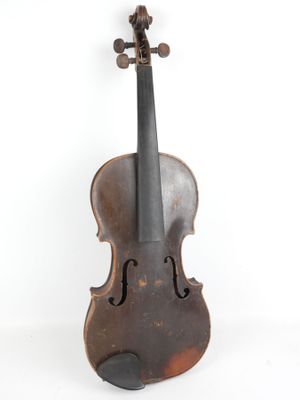 un vieux violon posé sur une surface blanche